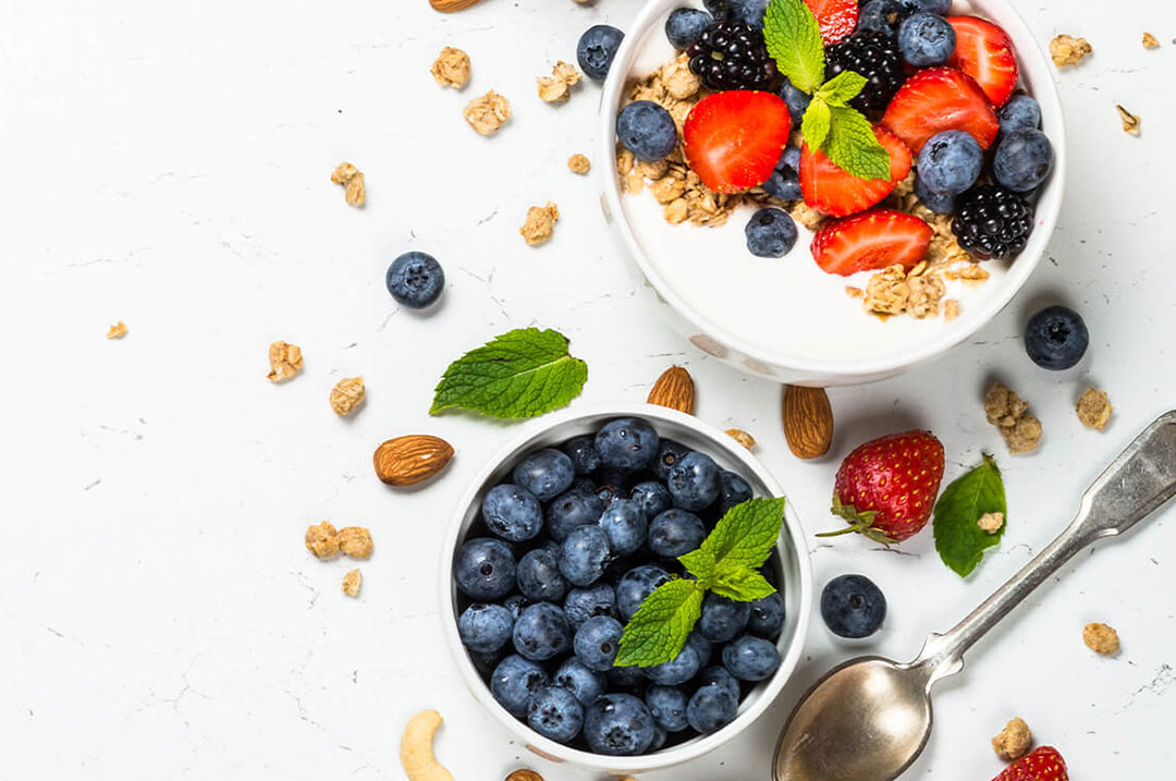 Granola and berries on white background